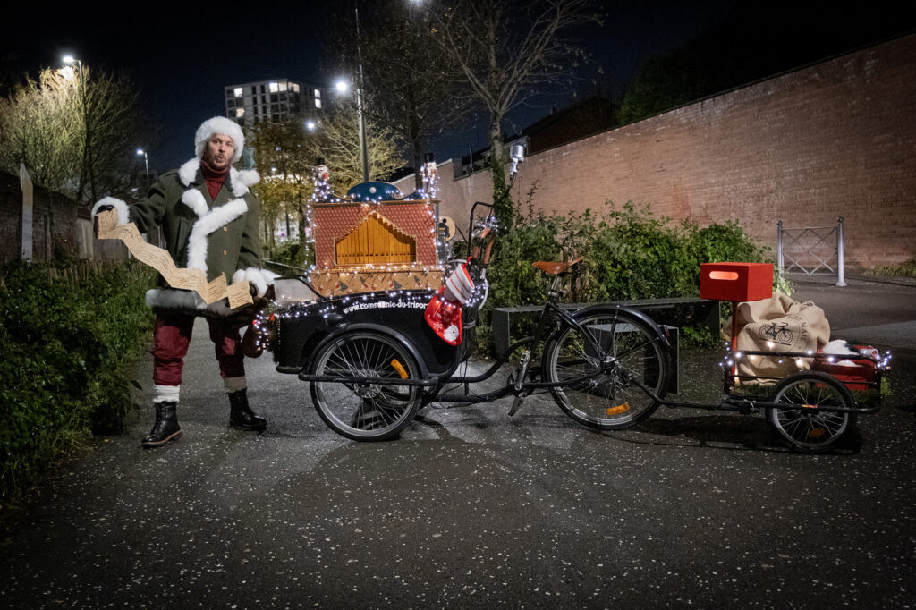 Noël chante Noël à côté de son triporteur plan large